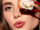 Model wearing spring makeup and holding sushi