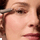 Applying shadow stick makeup to the eyelid in a close-up view