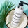 Aqua Bliss Cleansing Lotion bottle, displayed on a coconut