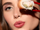 Model wearing spring makeup and holding sushi
