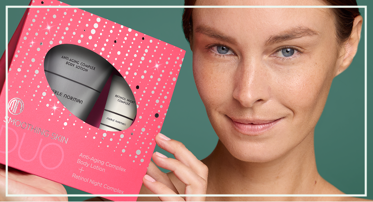 Boxed skincare gift set with multiple products held near the face